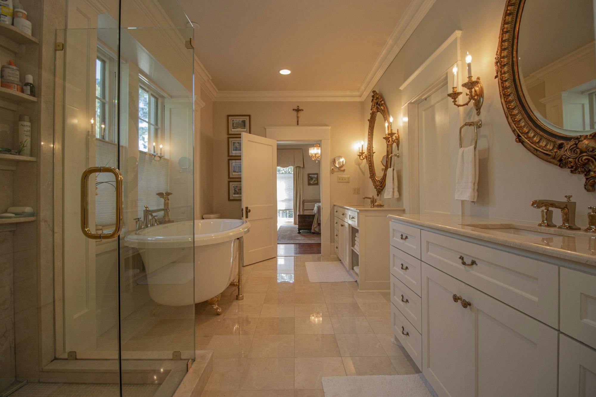 A classic marble bath with a gilt mirror and white vanity